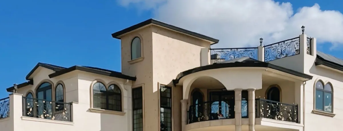 Upper facade of a custom stucco estate with arched windows and iron railings — custom stucco work in Santa Rosa