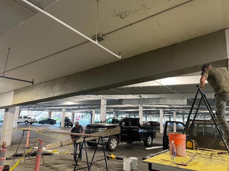 Crew installing exterior gypsum sheathing over metal framing in the parking structure (during)