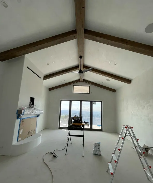 Vaulted great room with smooth venetian plaster walls and exposed wood beams — interior plaster in Santa Rosa