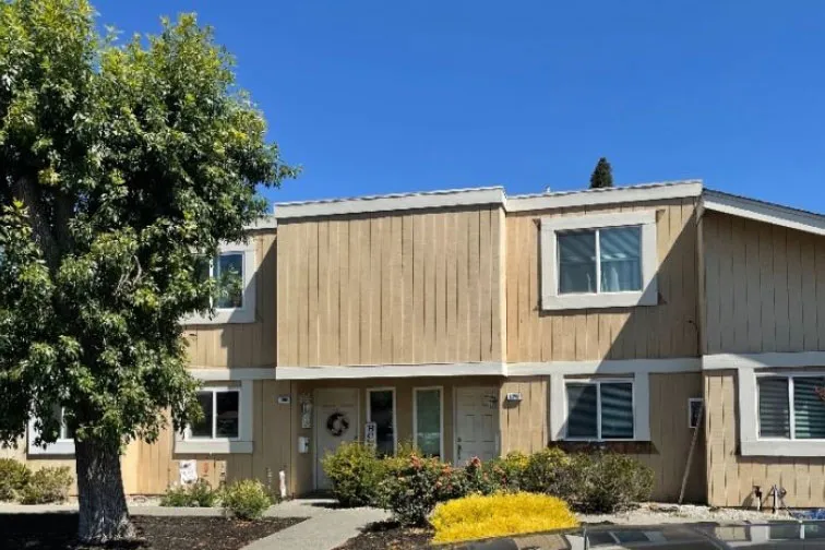 Townhome with original vertical wood siding before its stucco conversion (before)